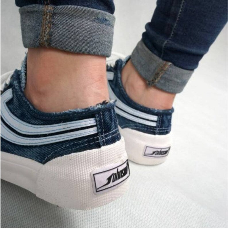 Urban Casual Close-up of feet wearing white sneakers with blue accents and a visible brand logo.