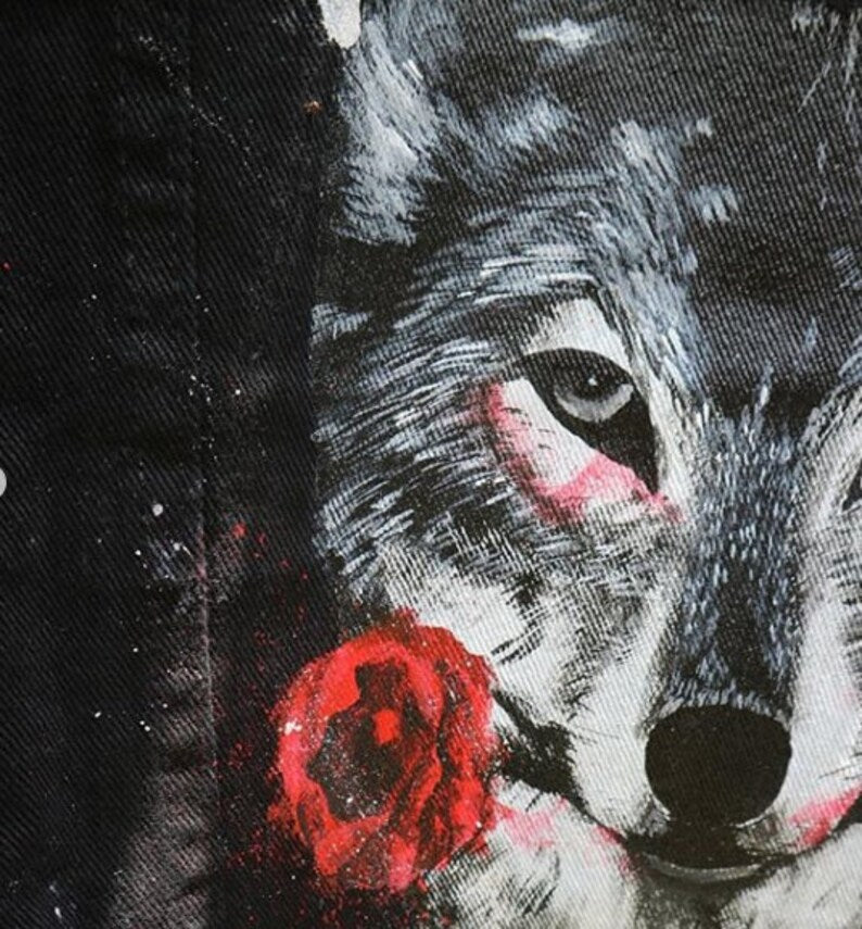 Artistic depiction of a wolf with a red rose on a denim jacket street art