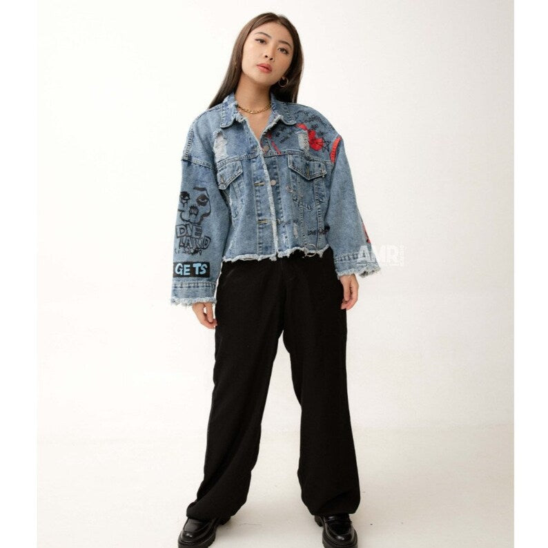 Person wearing a Grunge Clothing US denim jacket with embroidered designs on a white background