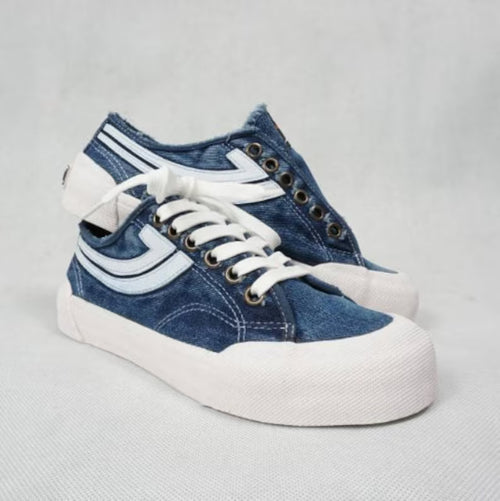 Pair of Denim blue sneakers with white laces on a light gray background