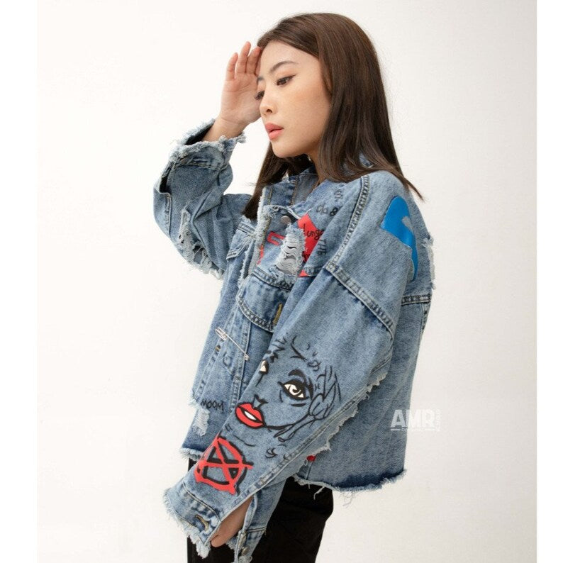 Woman wearing a Post Punk denim jacket with artistic designs on a white background