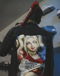 Person wearing a Harley Quinn Aesthetic Clothing denim jacket with a graphic design of a character
