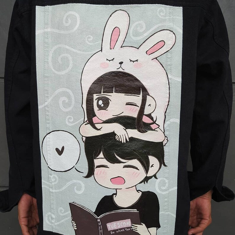 Illustration of a girl in a bunny costume reading a book held by a person.