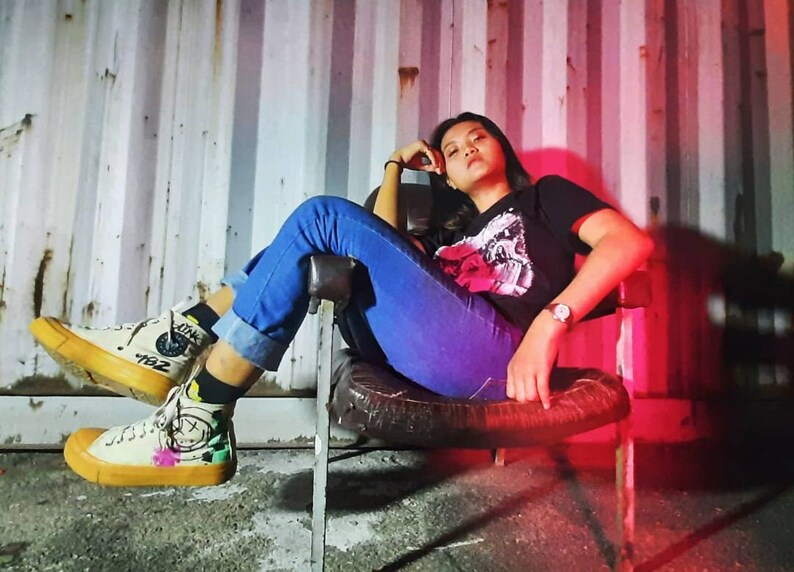 Person wearing hand-painted Blink-182 custom shoes with neon smiley logo for a punk rock skater outfit