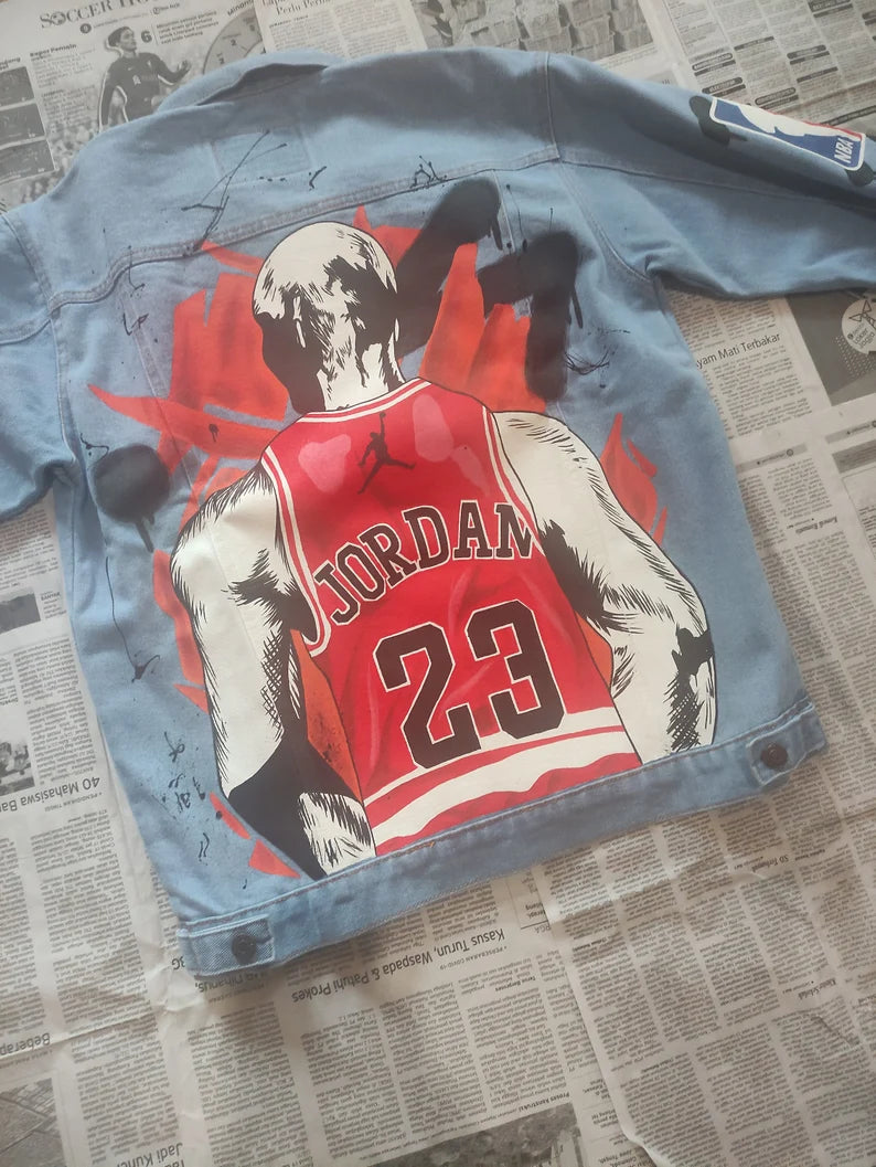 Hand-Painted Basketball Legend Denim jacket with a graphic of a basketball player in a red jersey on a newspaper background