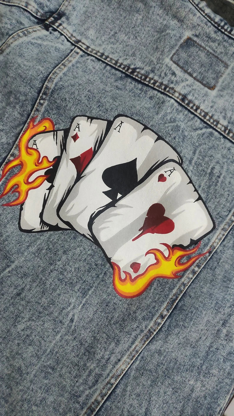 gambling Four playing card patches with flames on a denim background