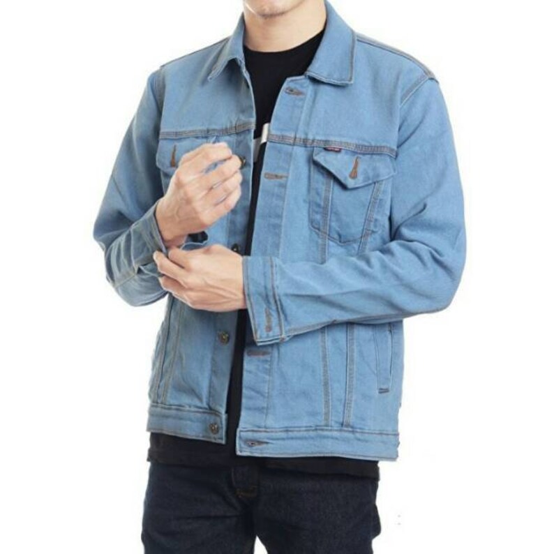 Person wearing a blue denim jacket on a white background