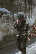 Person wearing a black oversized hand-painted denim jacket with colorful neon paint splatters for a Korean casual outfit