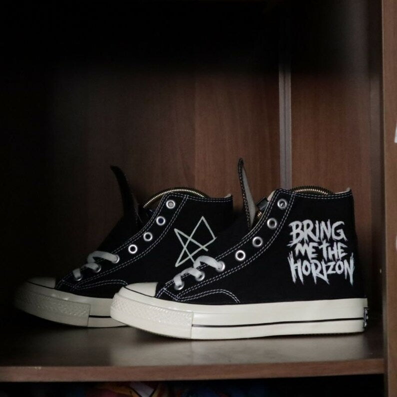Black sneakers with 'Bring Me the Horizon' text on a wooden shelf Emo-Punk Footwear