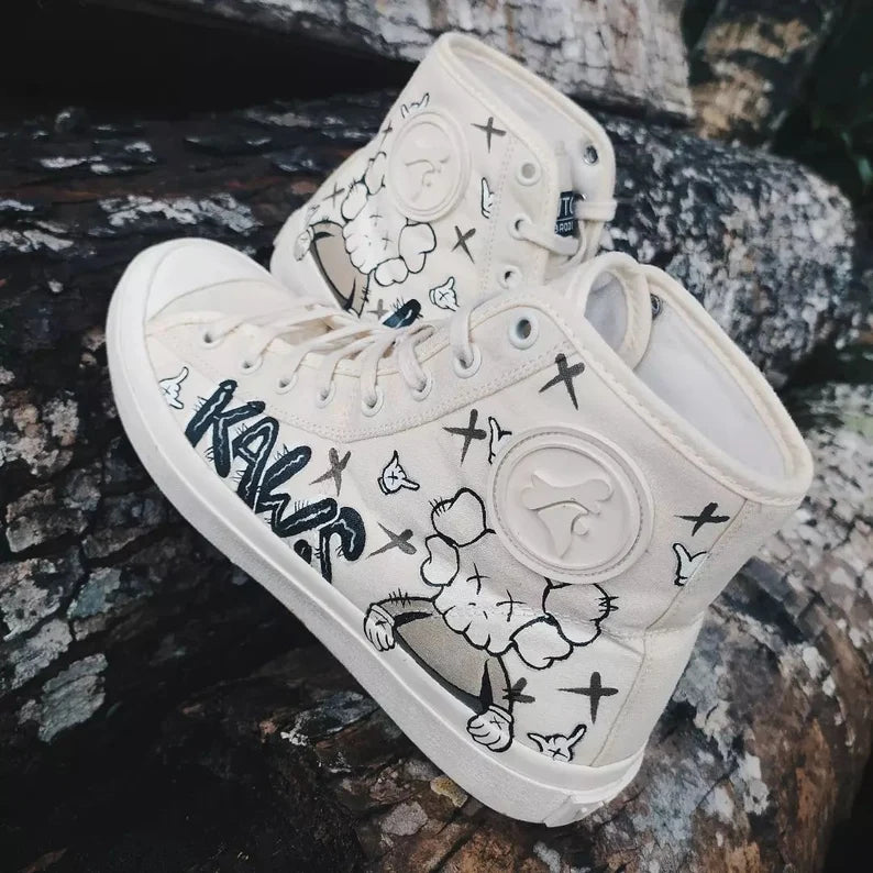 Street Art Footwear White sneakers with black doodle designs on a stone surface