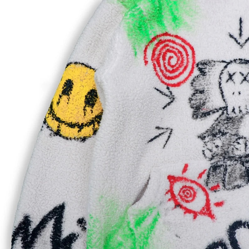 Urban Companion Art Jacket Close-up of a textured surface with colorful abstract designs including a smiley face, red spiral, and black text.