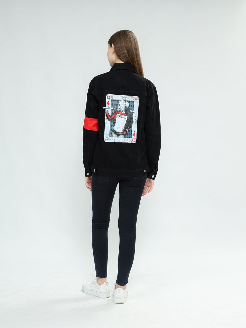 Person wearing a Harley Quinn denim jacket for a cosplay outfit with a graphic design on the back against a white background