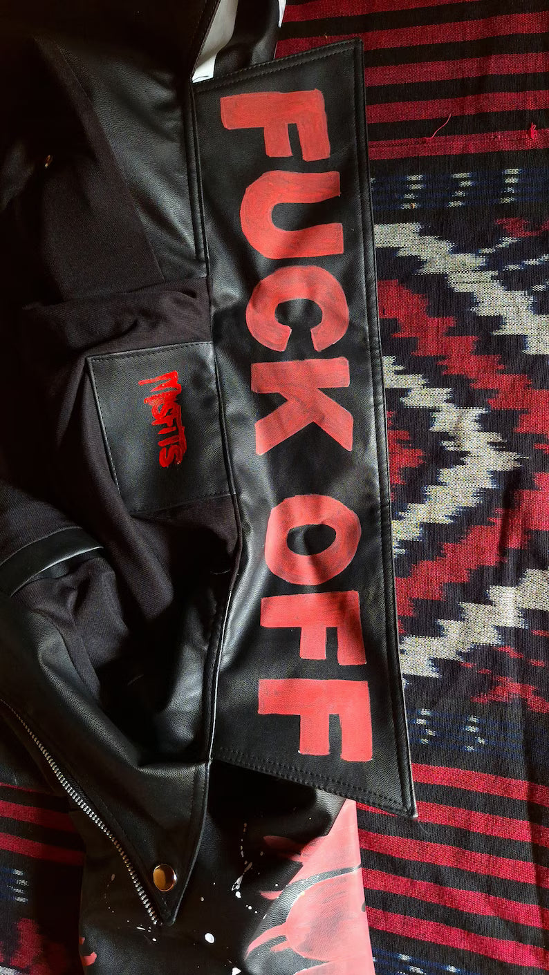 Horror Punk Outfit Ideas Black leather jacket with 'FUCK OFF' patch on a patterned fabric background