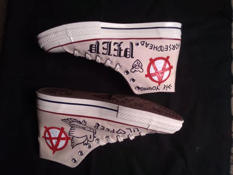 punk outfit idea Pair of high-top sneakers with visible branding and graphics on a black background