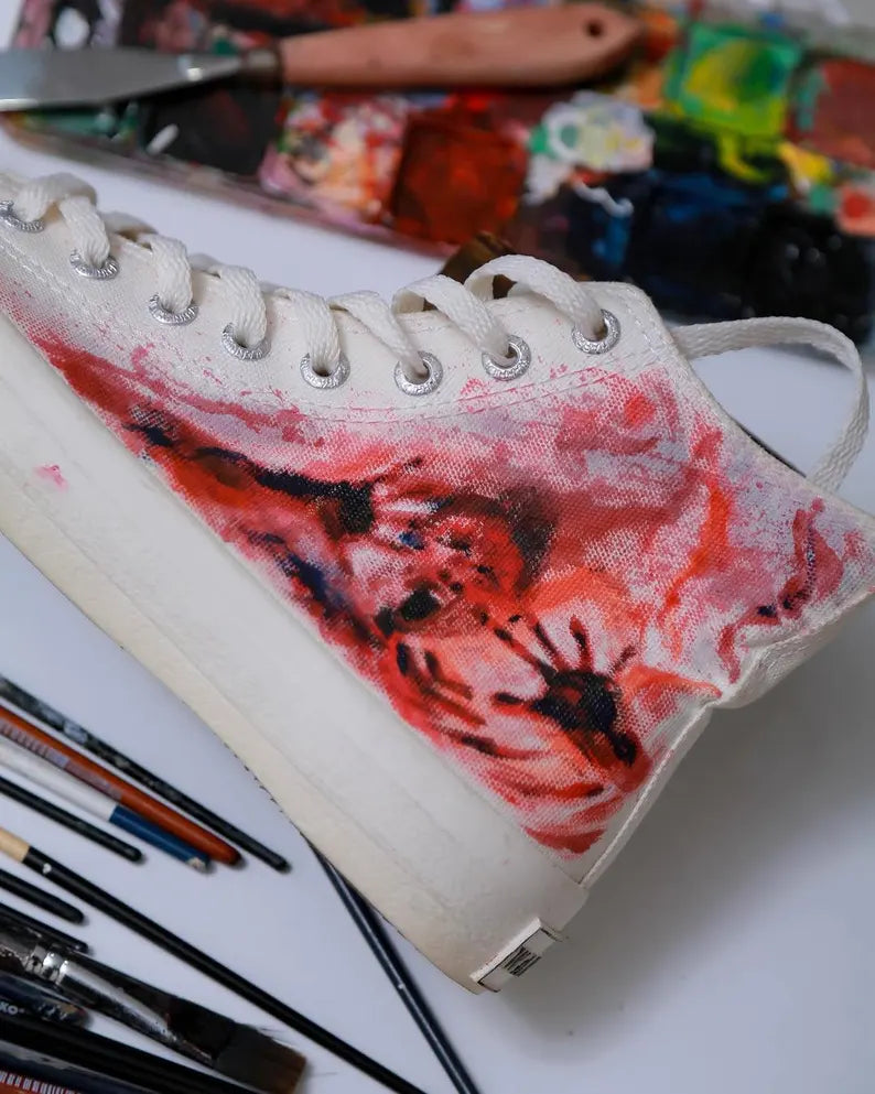 Hand Painted Gothic Sneakers with red and black design on a table with art supplies