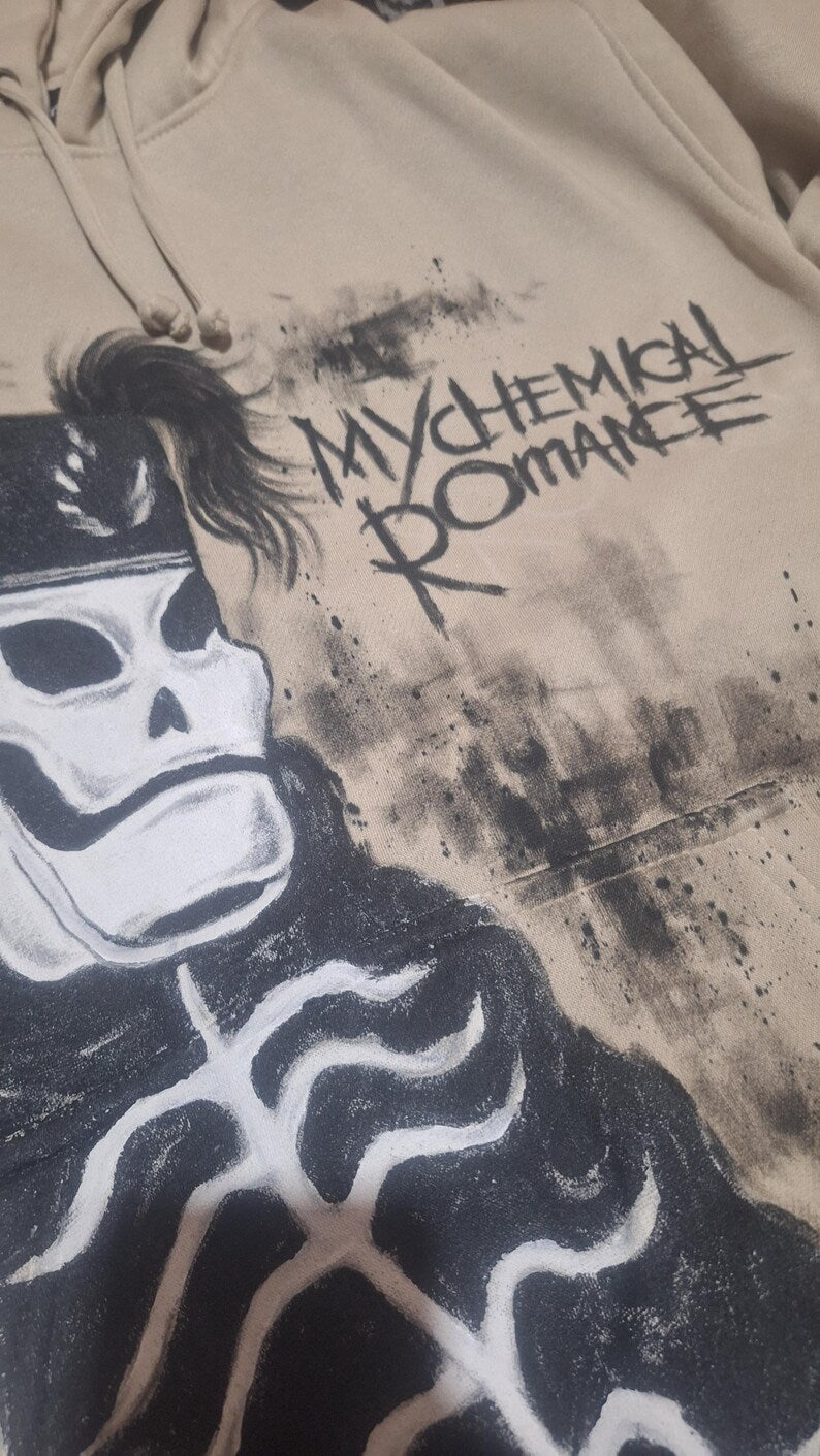 Hand Painted Emo Clothing with a graphic design of a skeleton and text 'Mychemical Romance' on a beige background.