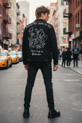 Person wearing a black hand-painted punk denim jacket with 'Roses are Blue' text and Bikini Bottom style street art