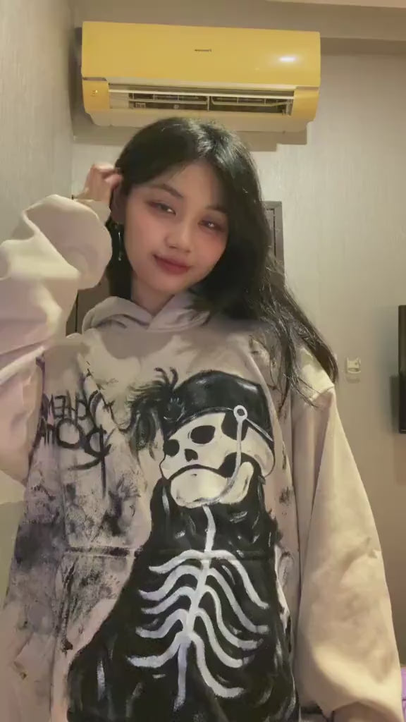 Person wearing a black hand-painted My Chemical Romance hoodie with white skeletal street art for a punk rock concert outfit