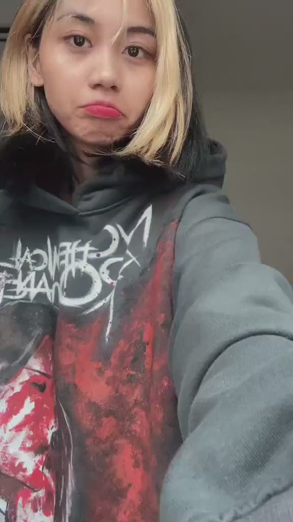 Person wearing a black hand-painted My Chemical Romance hoodie with white skeletal street art for a punk rock concert outfit